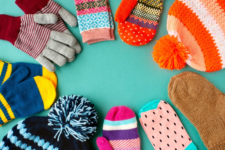 Caps, mittens, gloves and socks are stacked in a circle.