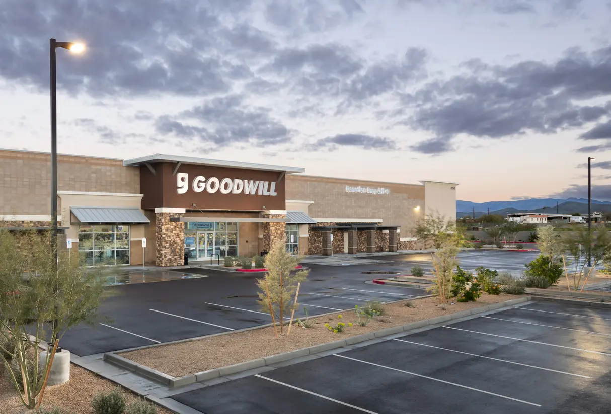 Goodwill AZ | Someone looking through racks of white shirts on hangers