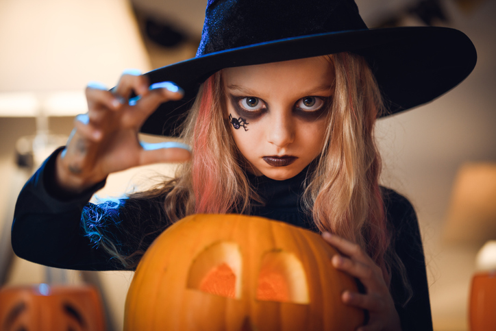 young girl wearing a witch costume