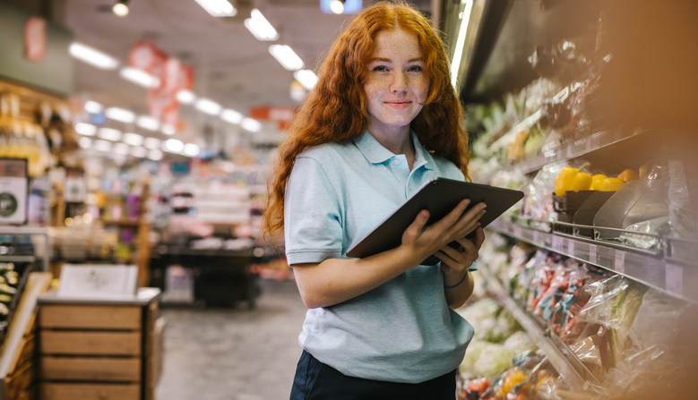 young lady with a tablet in hand managing a supermarket
