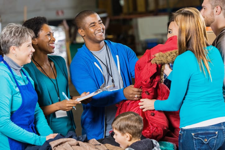 Goodwill AZ | Volunteers passing out coats at winter clothing donation drive