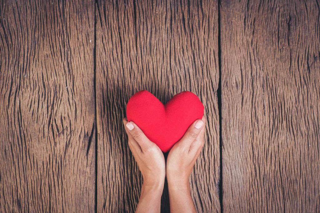 Goodwill AZ | Hands holding a small red heart pillow