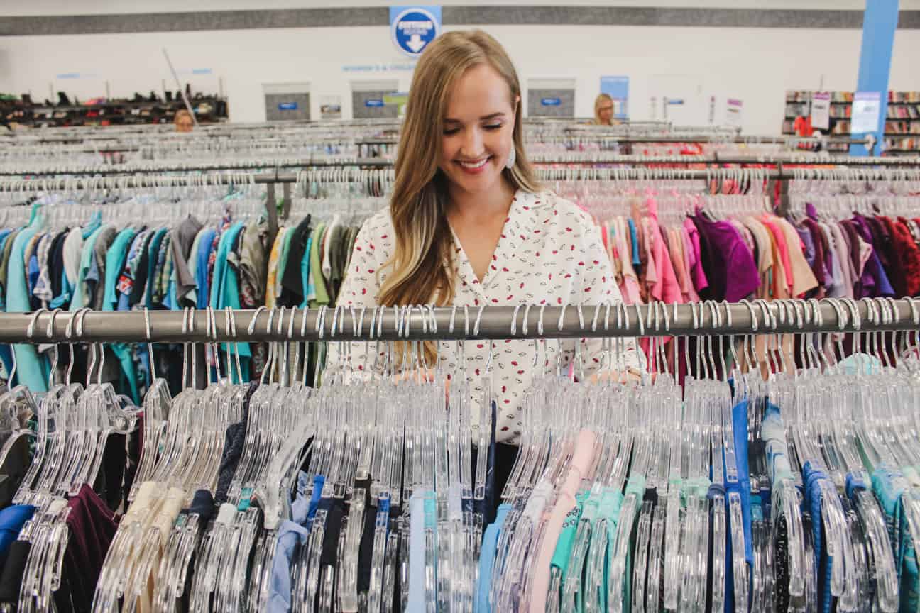 Goodwill AZ | Someone looking through racks of white shirts on hangers