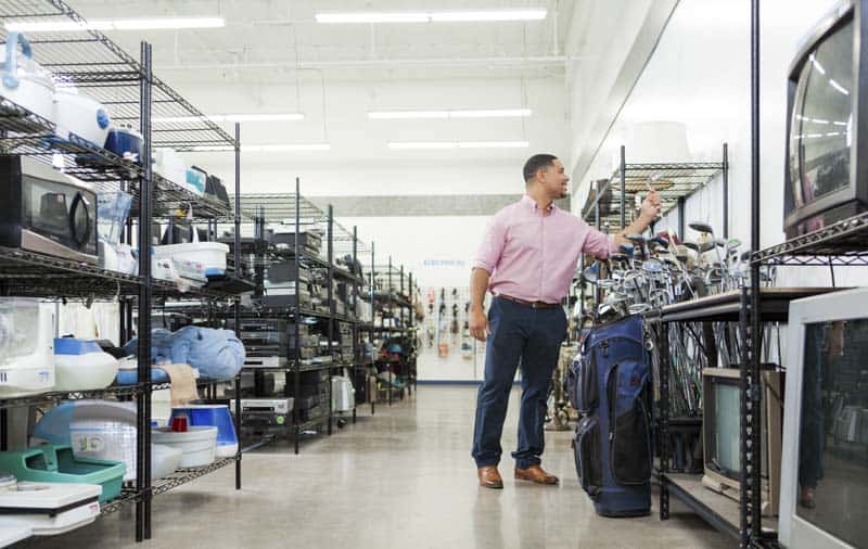Goodwill AZ | man looking at donated golf clubs in store