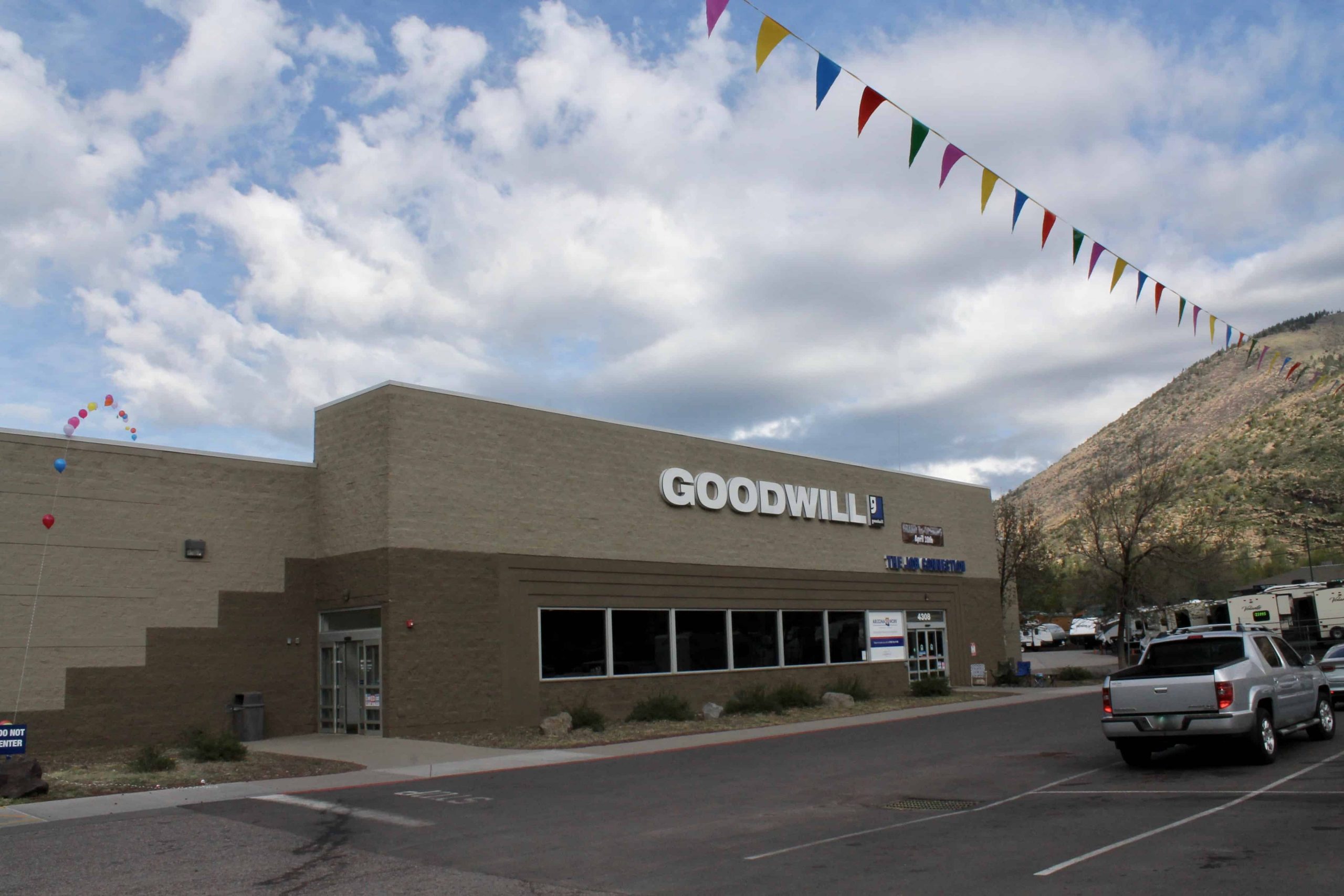Goodwill AZ | Someone looking through racks of white shirts on hangers