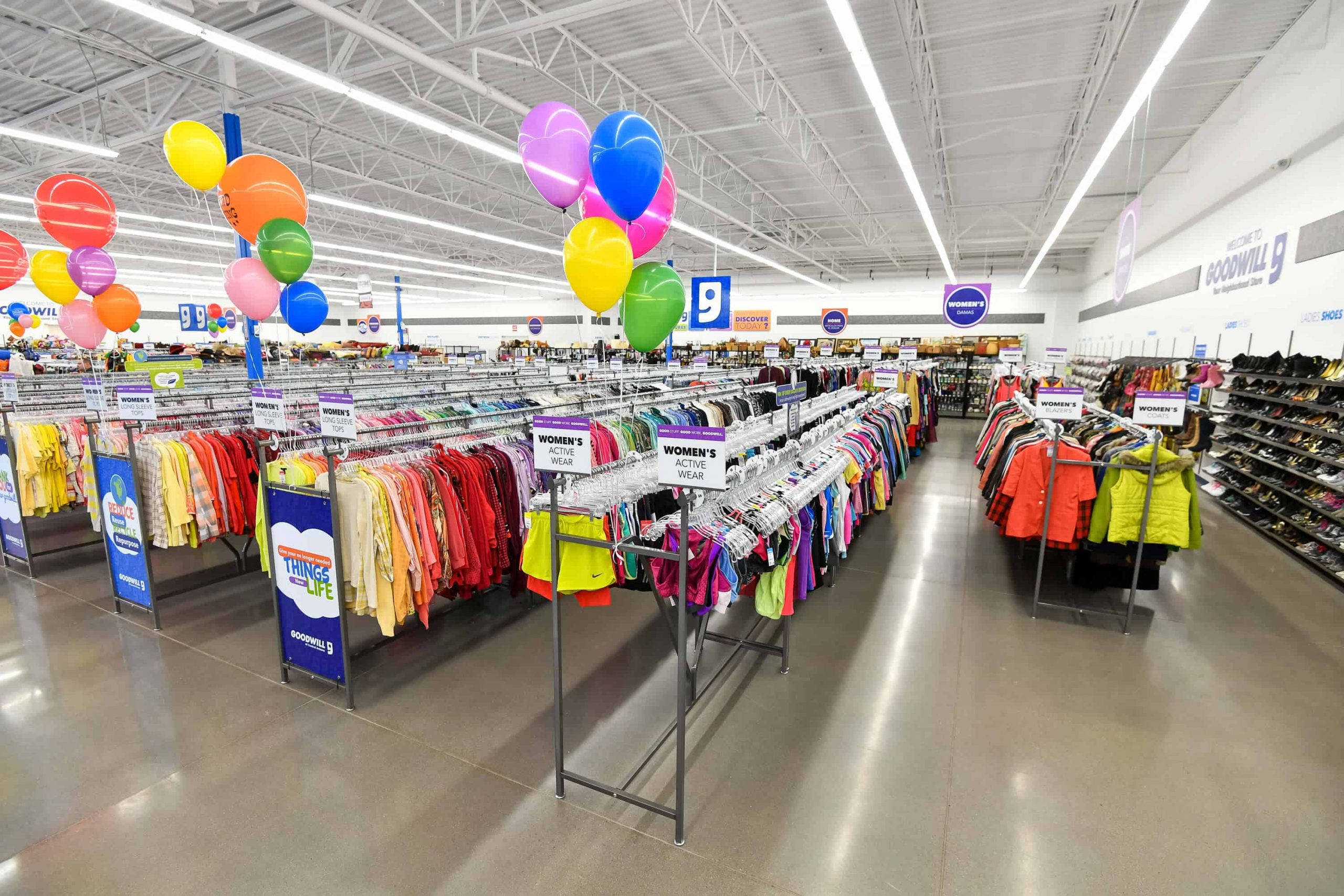 Goodwill AZ | Someone looking through racks of white shirts on hangers
