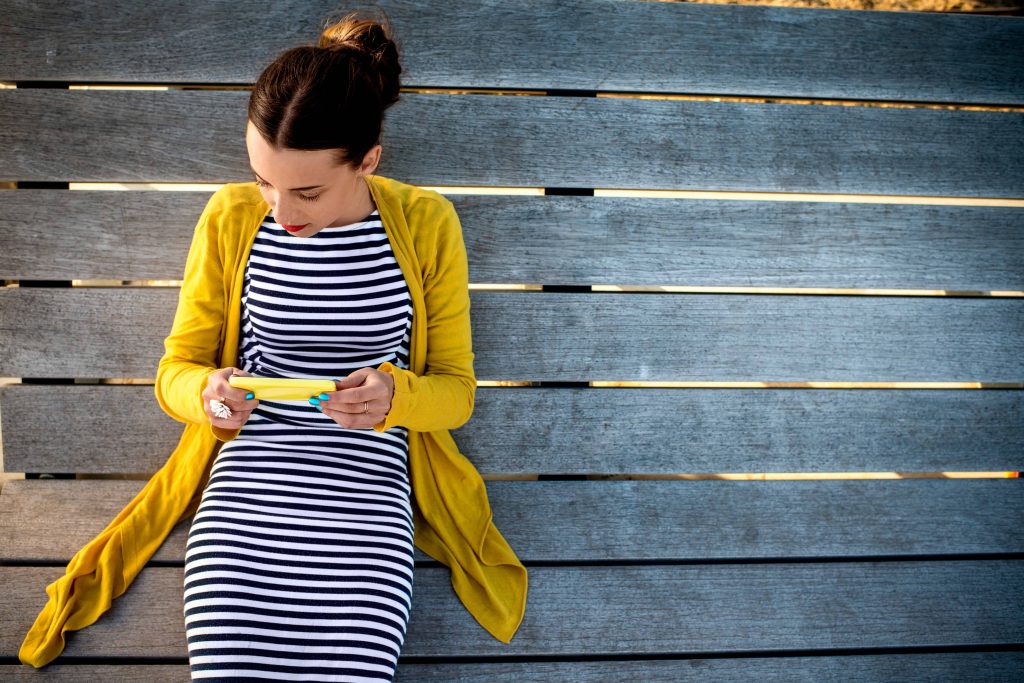 Goodwill AZ | Women in a striped dress and yellow cardigan