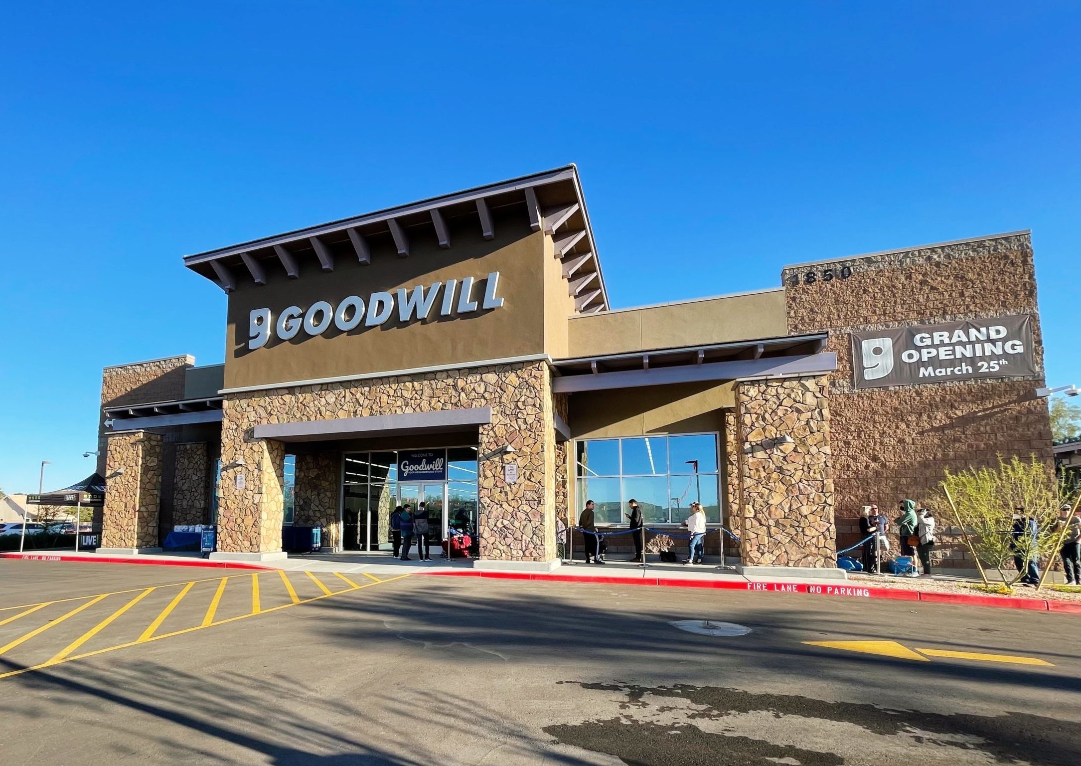Goodwill AZ | Someone looking through racks of white shirts on hangers