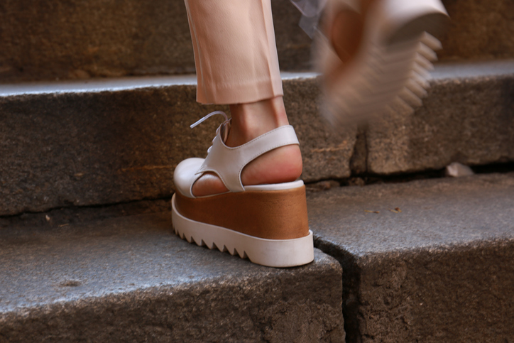 womans feet walking up stairs in platform sandals