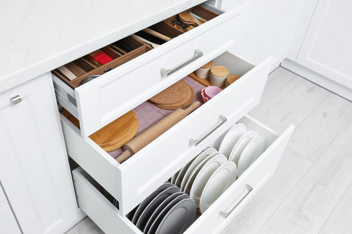 Open drawers with cutlery and utensils indoors. Order in kitchen