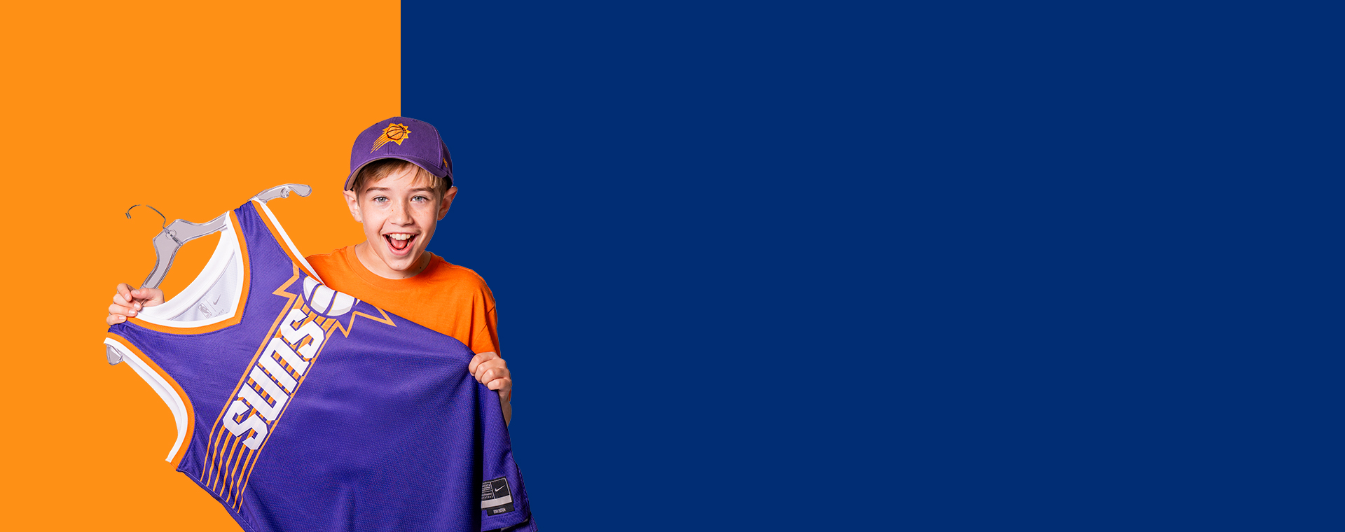 A kid holding a Suns Jersey
