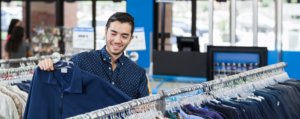 A man looking at racks of clothing