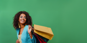 Woman with blue blazer smiling holding shopping bags over her shoulder