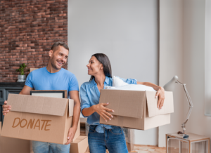 A smiling man and woman holding donation boxes