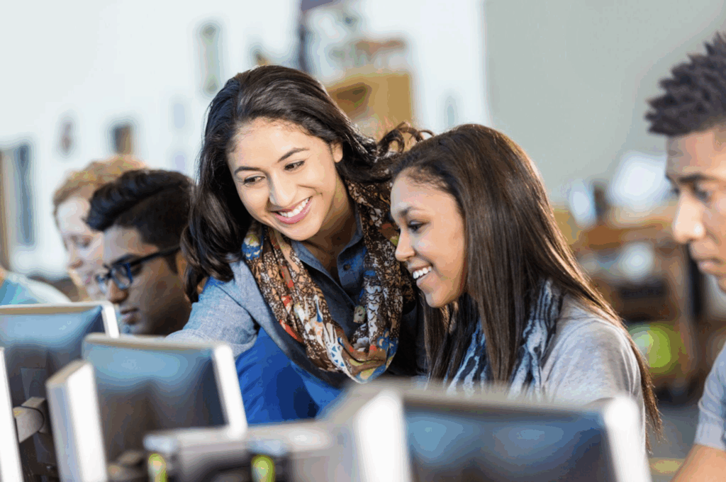 A women helping another women with a computer