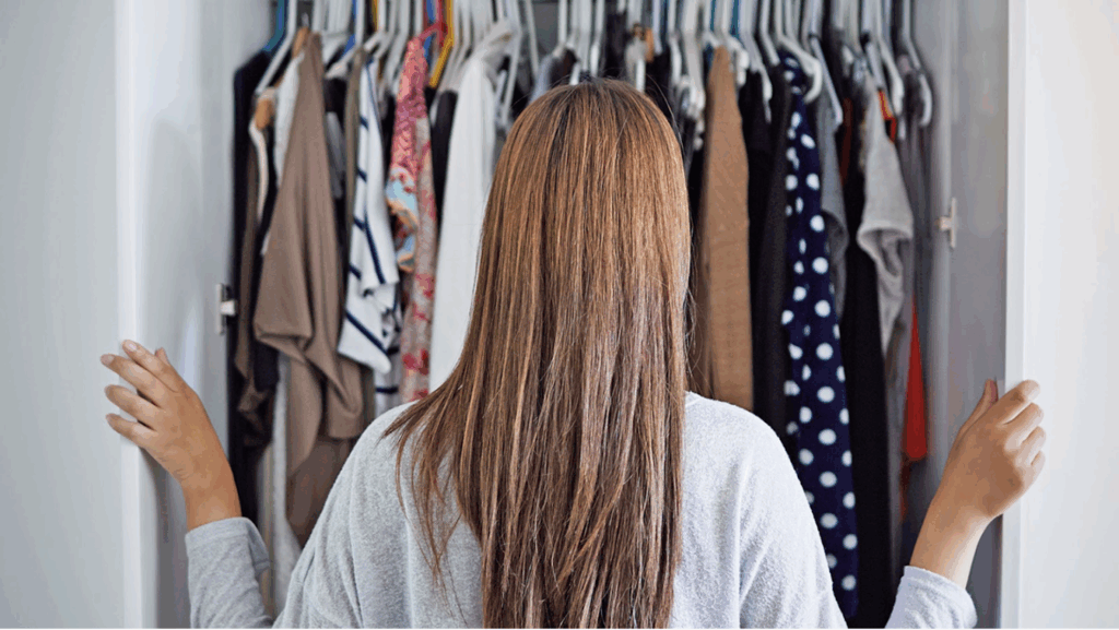 A women looking in her closet at her clothing