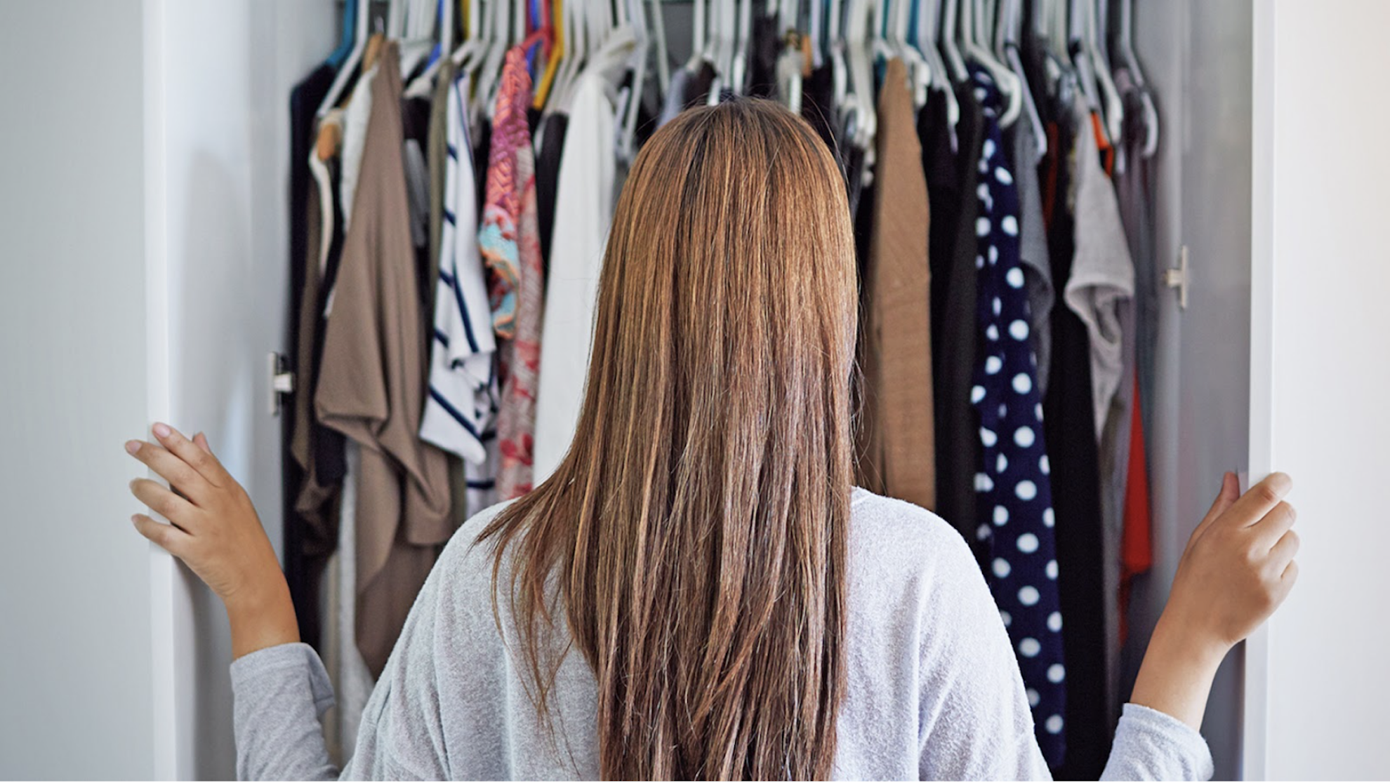 Goodwill AZ | Someone looking through racks of white shirts on hangers