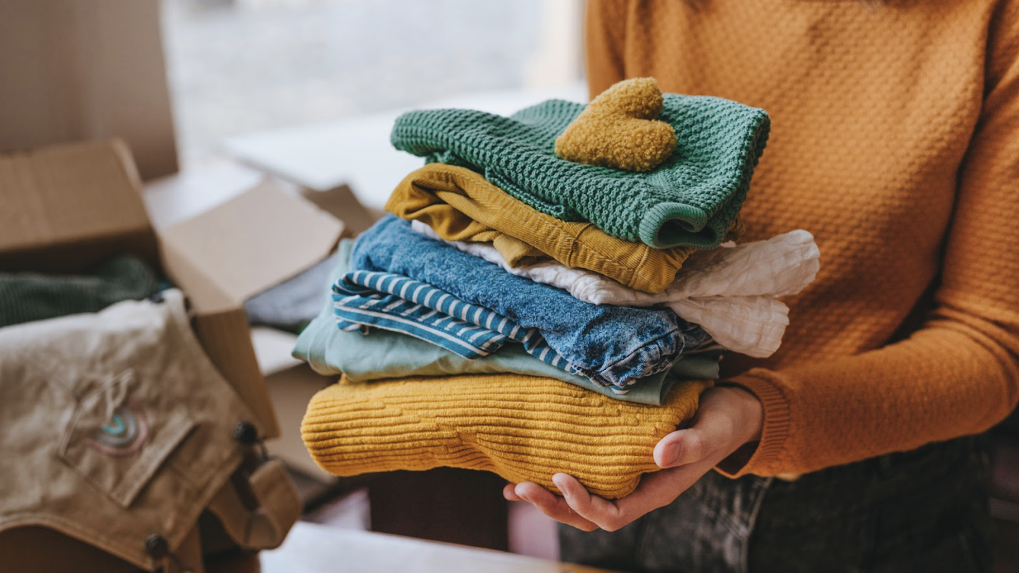 Goodwill AZ | Someone looking through racks of white shirts on hangers