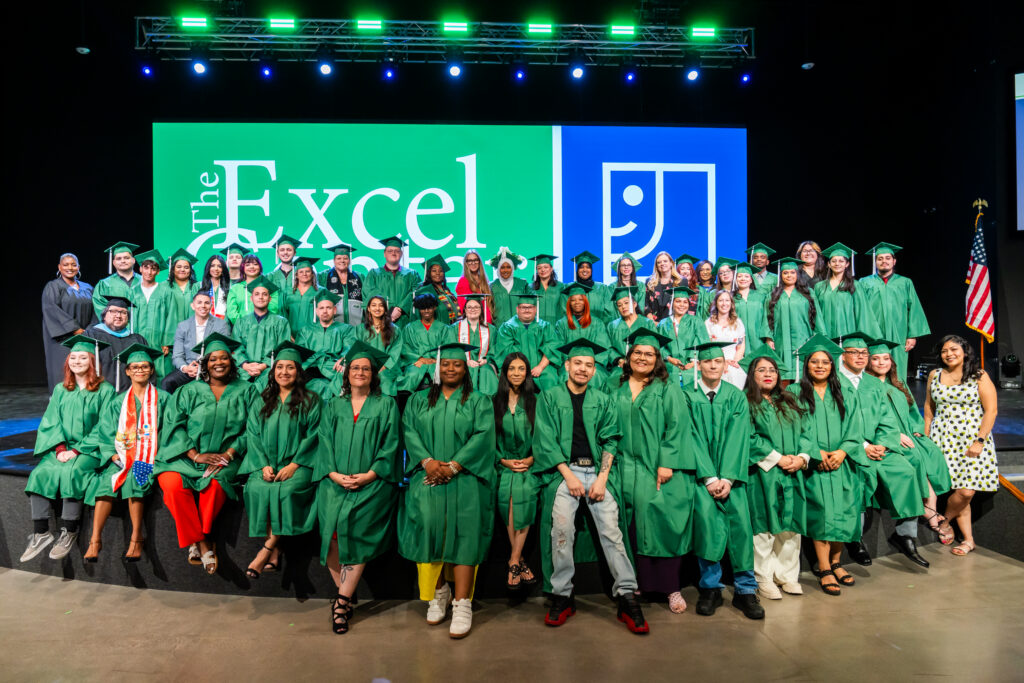 A large group of people on a stage wearing graduation uniform