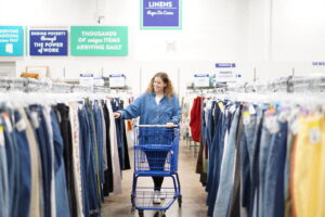 A customer shops through a rack of jeans at Goodwill