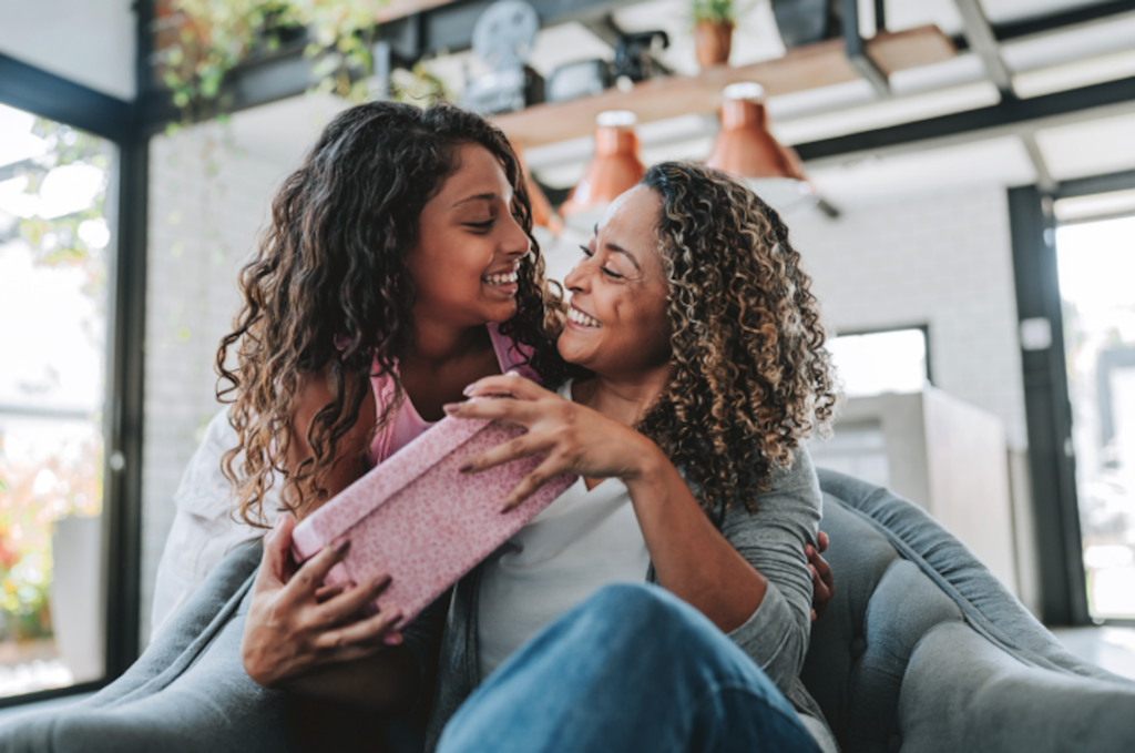 Mother and daughter opening a gift