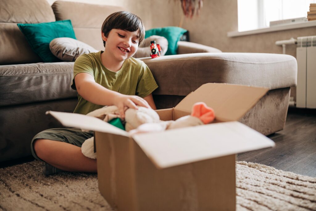 A young boy putting items in a box