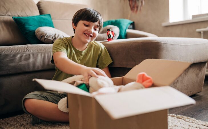 A young boy putting items in a box
