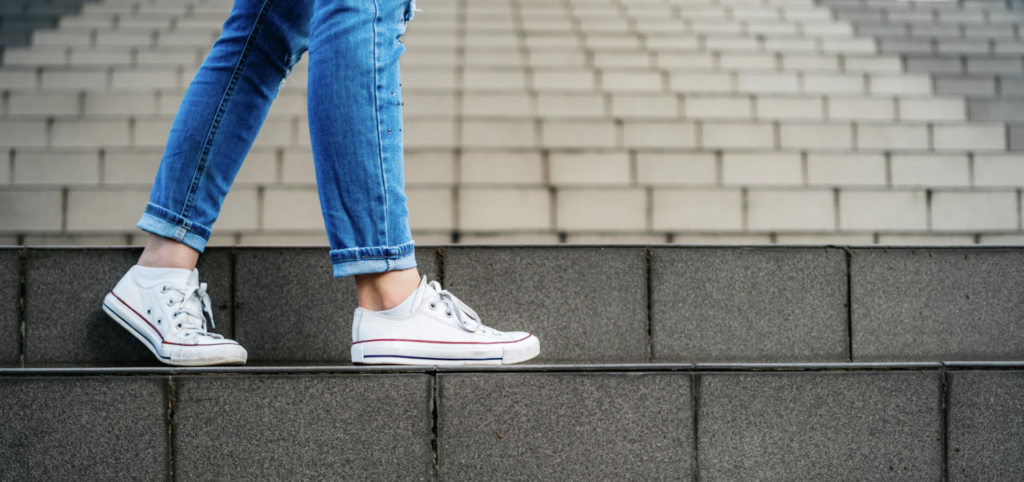 Girl wearing jeans and brand new white sneakers on a set of stairs