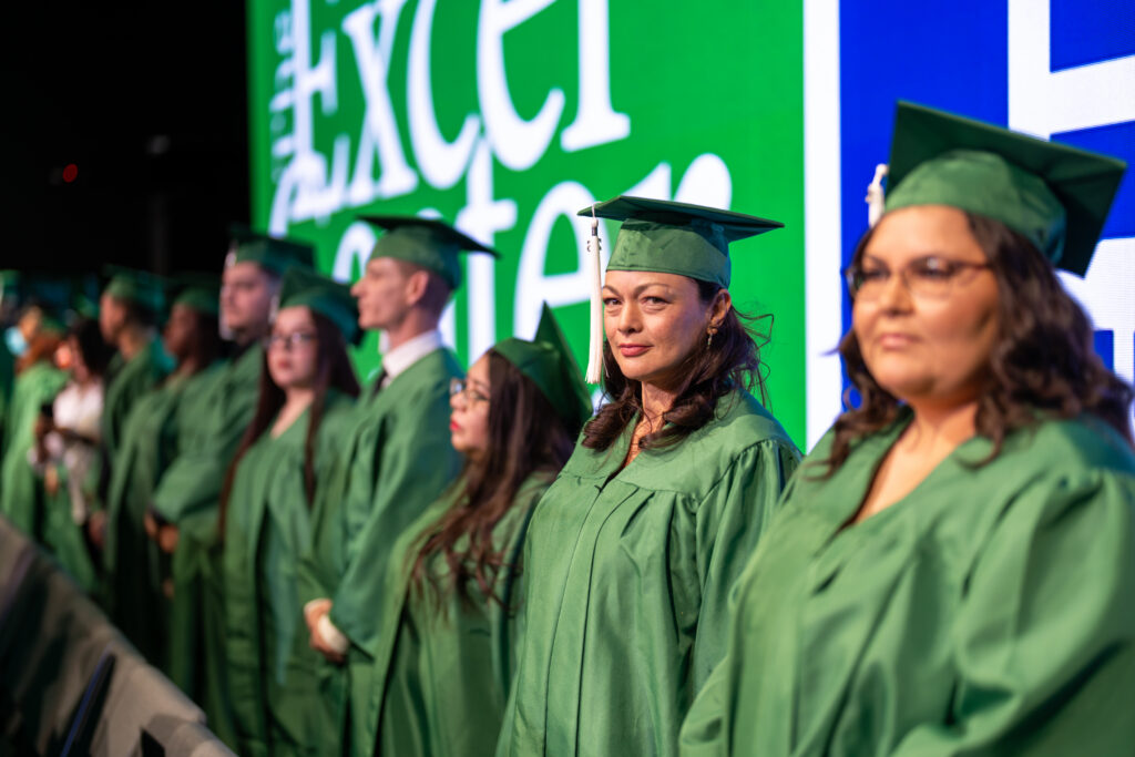 Excel Center graduates standing at graduation ceremony