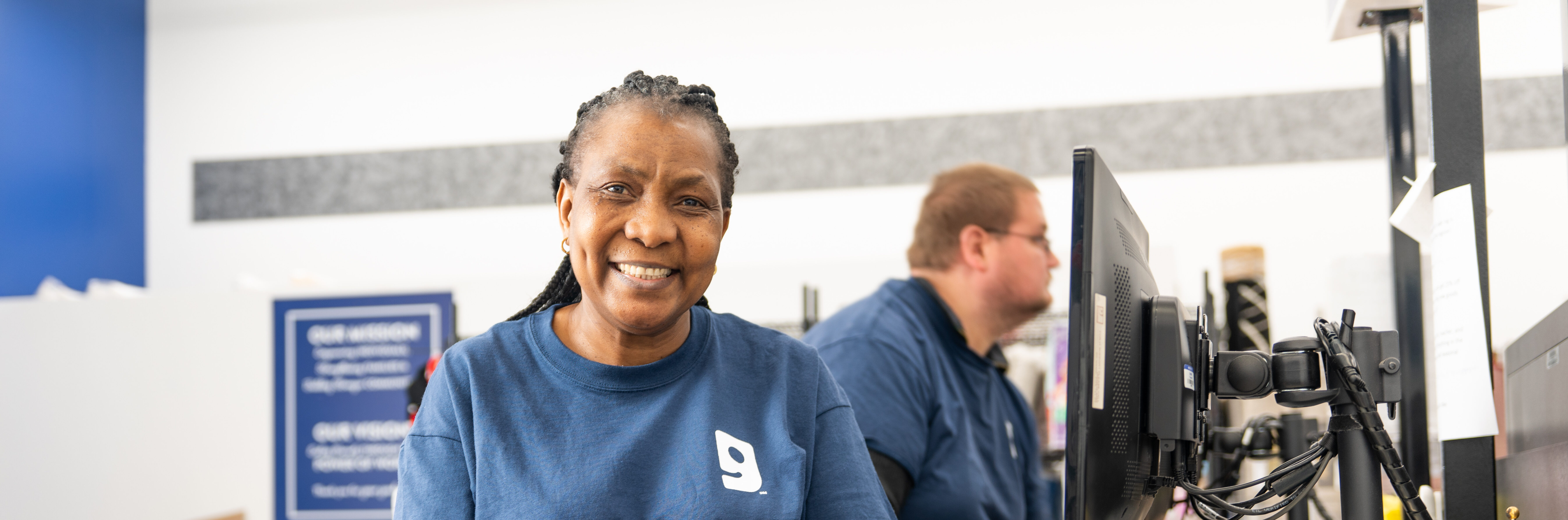 Two Goodwill Employees by computers